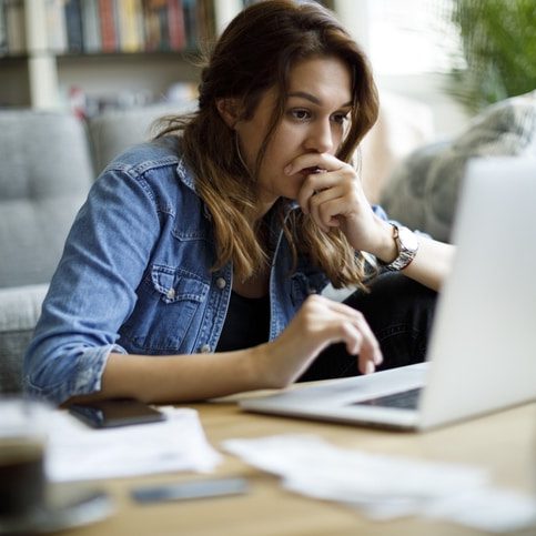 Worried young woman working at home